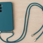 Image d'un Samsung Galaxy A14 protégé par une coque de couleur bleu avec un cordon, posé sur une surface en bois, mettant en avant son design élégant et pratique.