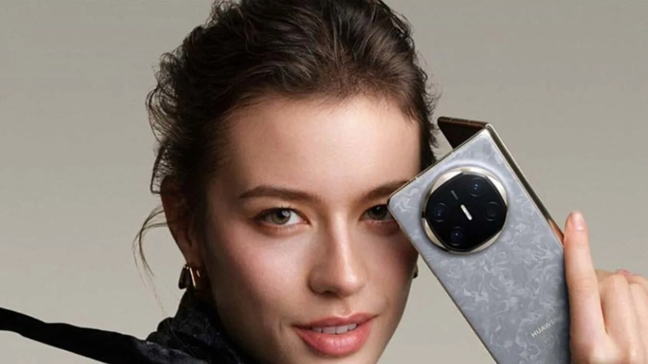 Femme tenant le Huawei Mate X7 gris en main, montrant le grand module photo circulaire.